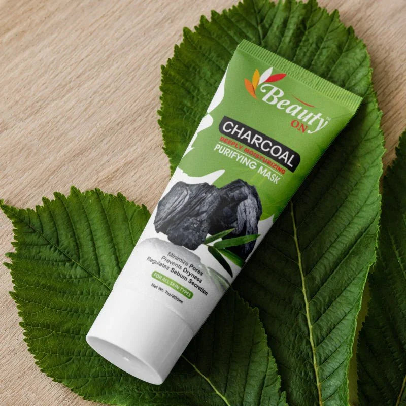 Charcoal purifying mask for all skin types, sulfate-free, cruelty-free, on green leaf background