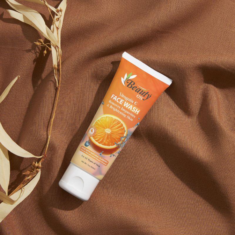 Vitamin C face wash for brightening skin, sulfate-free, with orange extract on brown fabric background