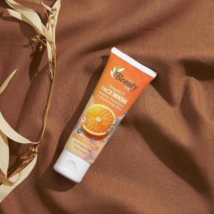 Vitamin C face wash for brightening skin, sulfate-free, with orange extract on brown fabric background