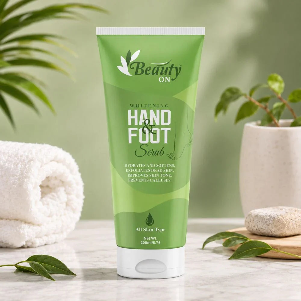 Green tube of hand and foot scrub for all skin types, hydrates and softens, with towel and plants nearby